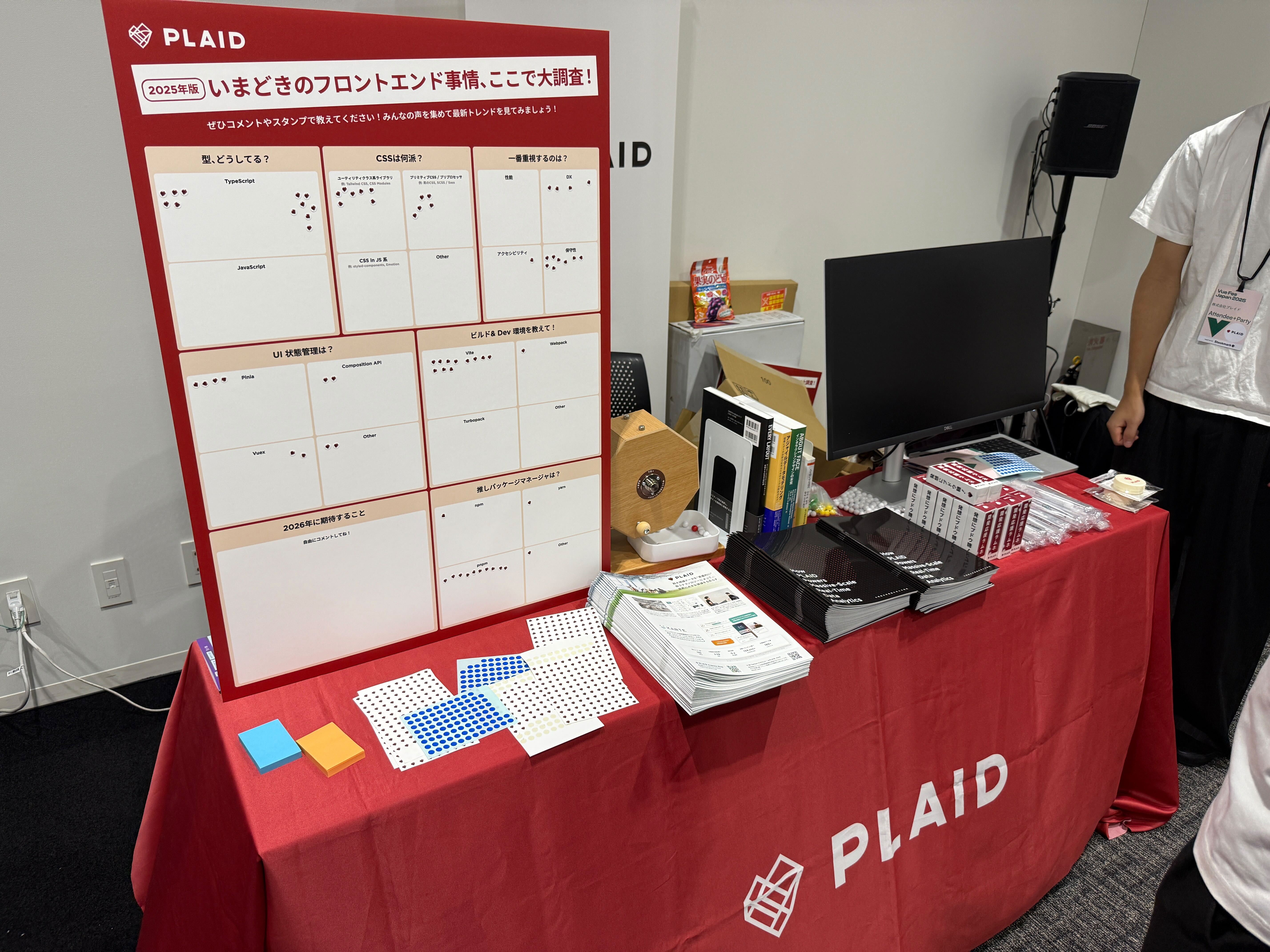 Vue Fes Japan 2025の株式会社プレイドのブースの様子。パンフレットやモニター、アンケートボードが並べられている。